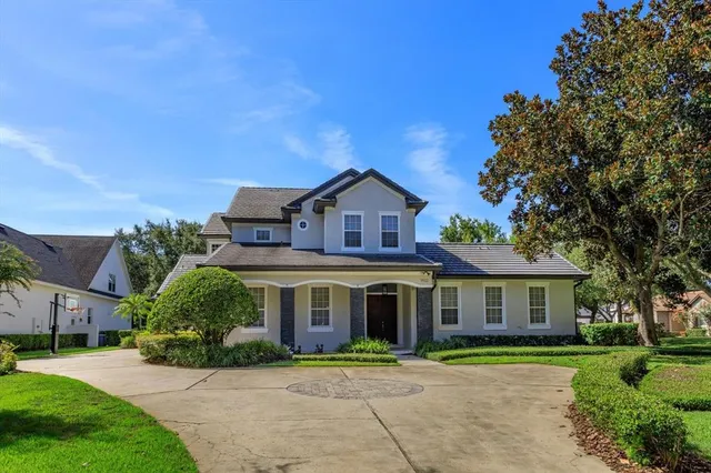 a view of house with garden and tall trees