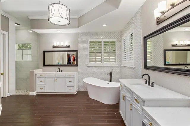 a spacious bathroom with a double vanity sink a mirror and a bathtub