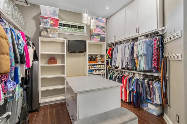 a view of walk in closet with clothes and shoes