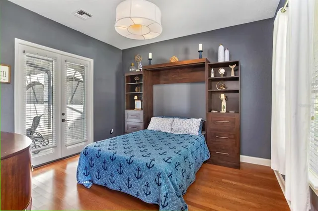 a bedroom with a large bed and wooden floor