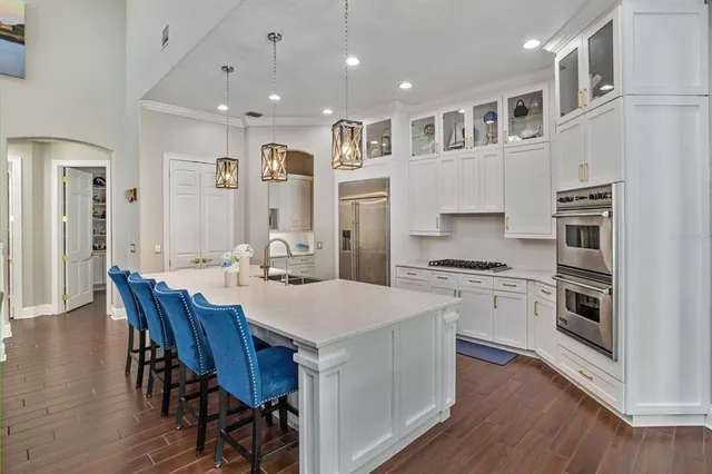 a large kitchen with cabinets wooden floor and stainless steel appliances