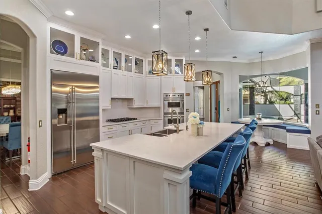 a kitchen with stainless steel appliances kitchen island granite countertop a refrigerator and a stove top oven