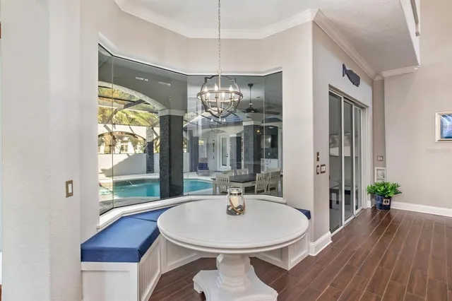 a dining room with wooden floor a chandelier a wooden table and chairs
