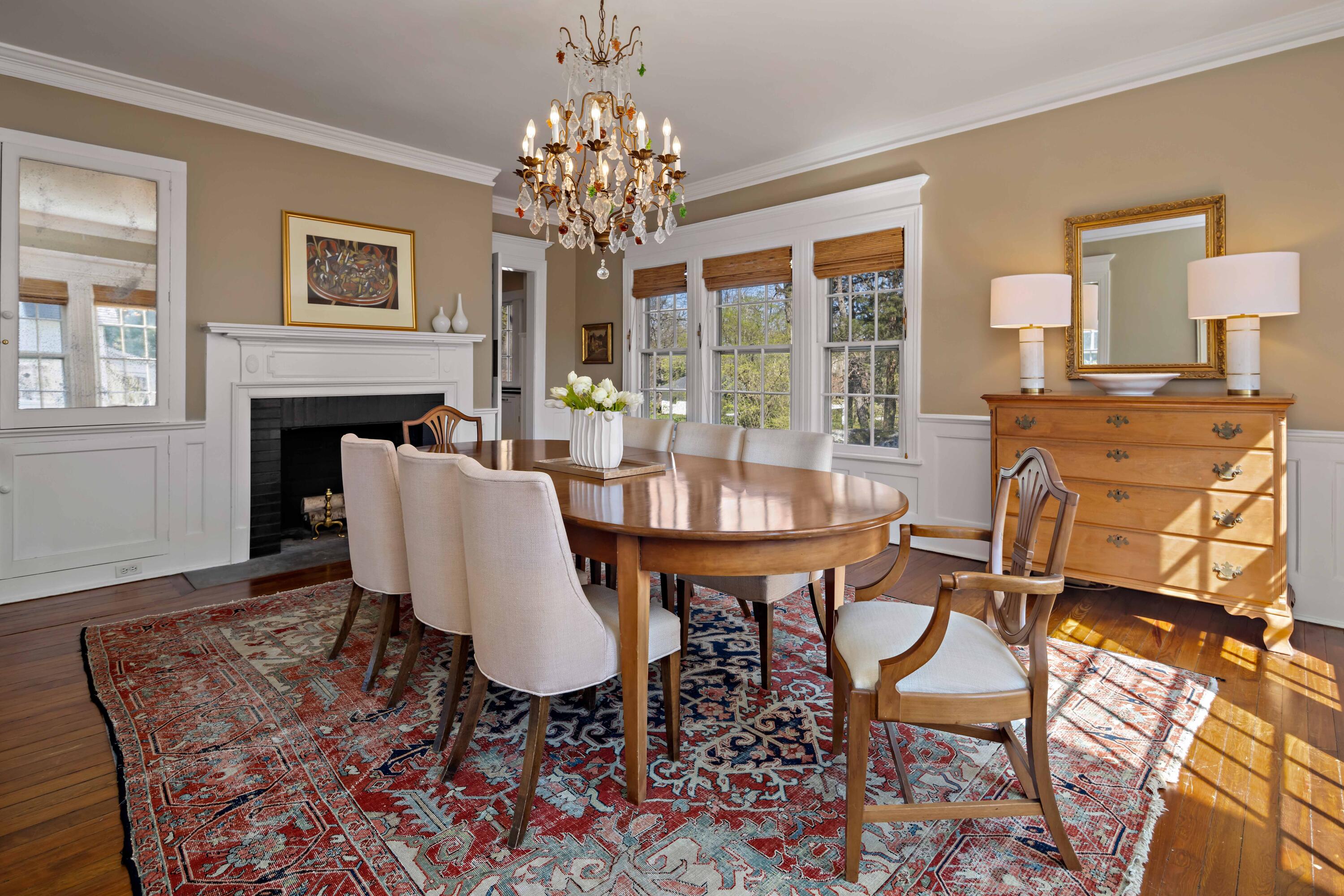 3 Edgehill Drive Darien, CT 06820 - Photo 11 of 40 a dining room with furniture a rug a fireplace and a chandelier