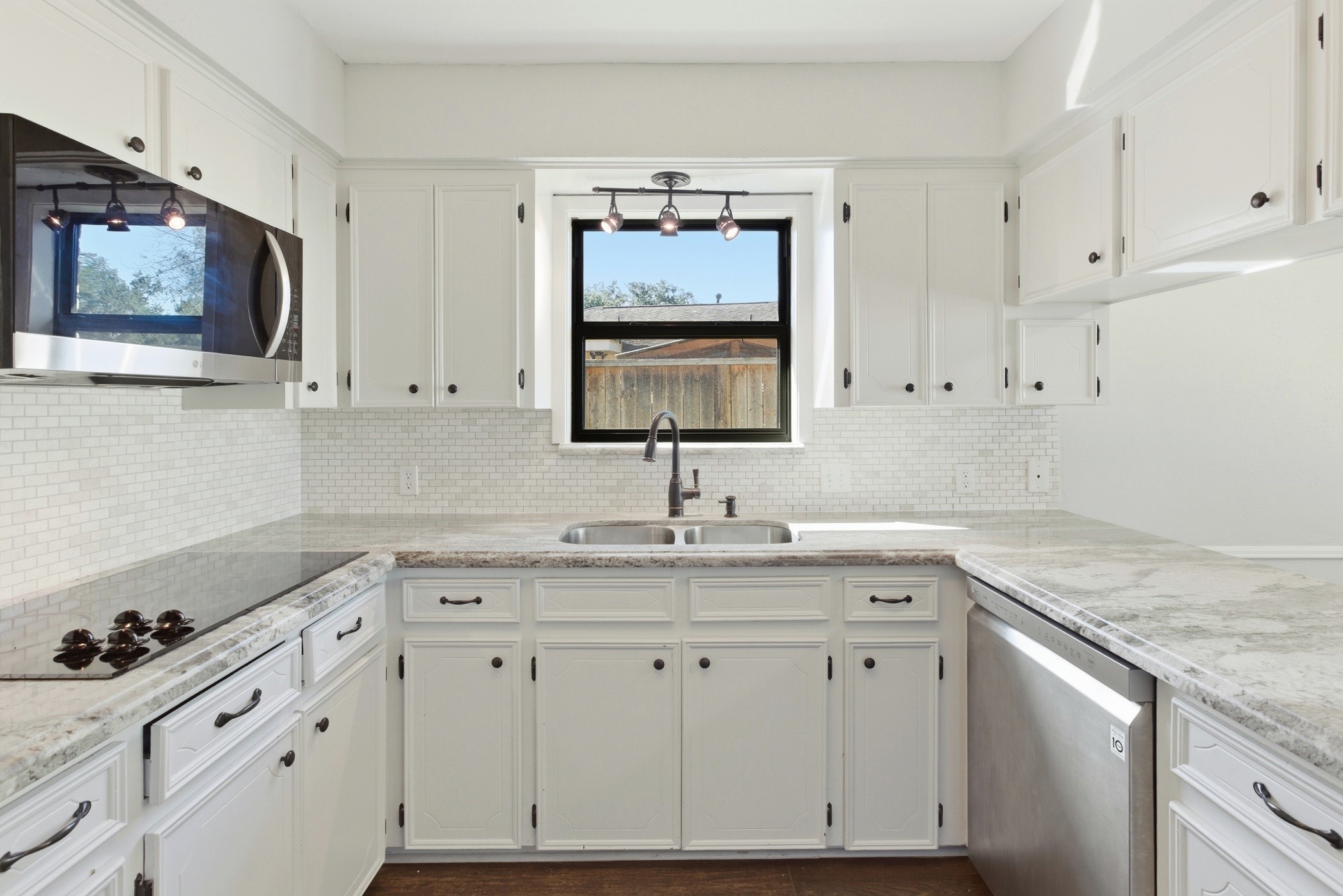3721 Avenue R Rosenberg, TX 77471 - Photo 16 of 43 Granite countertops and tile backsplash with window overlooking backyard.