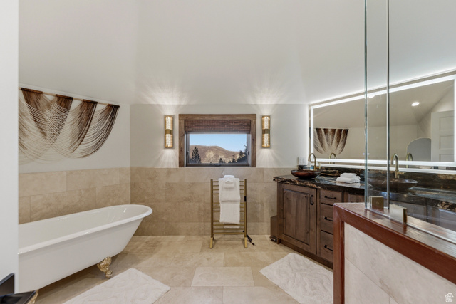 2687 Stewart Road Sundance, UT 84604 - Photo 12 of 48 Full bathroom featuring vanity, a freestanding tub, a wainscoted wall, tile walls, and light tile patterned floors