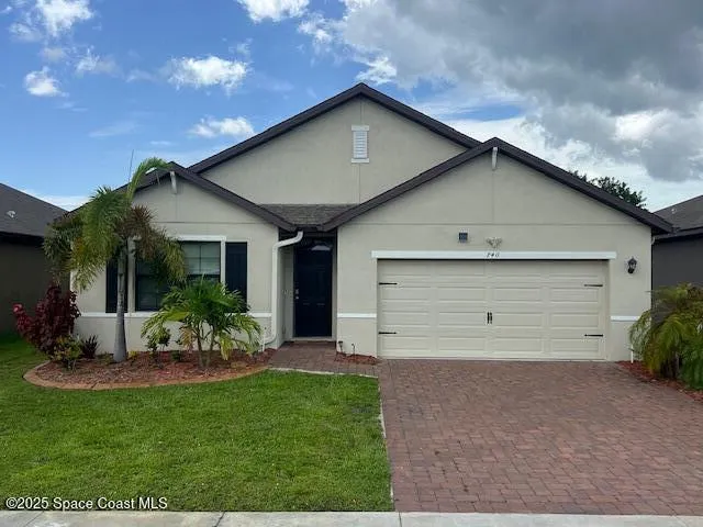 a front view of a house with a garden and plants