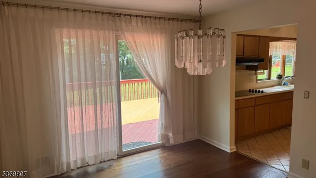 a view of a room with window wooden floor and front door