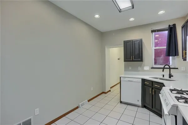 a kitchen with stainless steel appliances a sink stove and cabinets