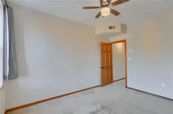 an empty room with a ceiling fan and a window