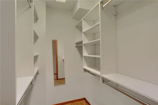 a view of walk in closet with empty racks