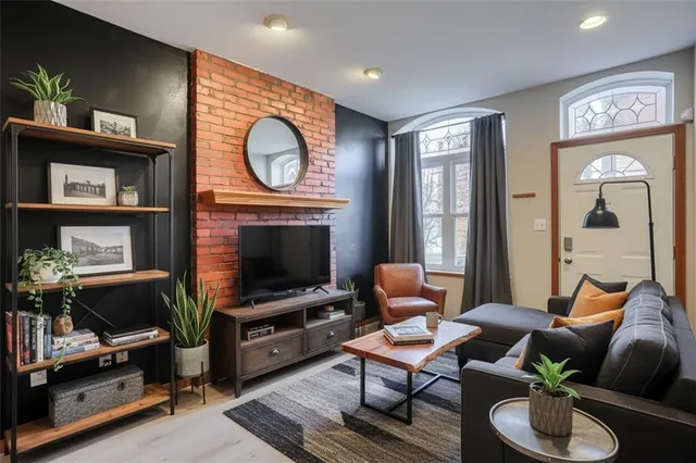 a living room with furniture a window and a flat screen tv