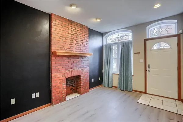 an empty room with windows and fireplace