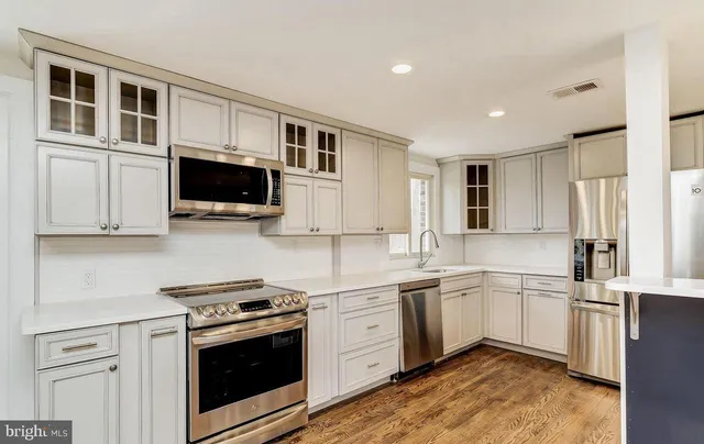 a kitchen with stainless steel appliances white cabinets and a sink
