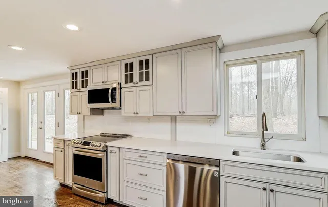 a kitchen with kitchen island a refrigerator and a sink