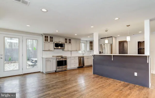 a kitchen with stainless steel appliances kitchen island granite countertop a refrigerator and a sink