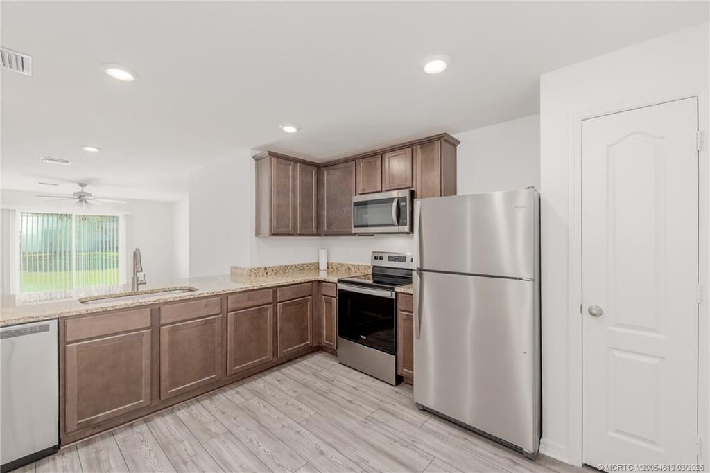 2108 Southwest Vista Road Port St. Lucie, FL 34953 - Photo 8 of 19 a kitchen with white cabinets and white appliances