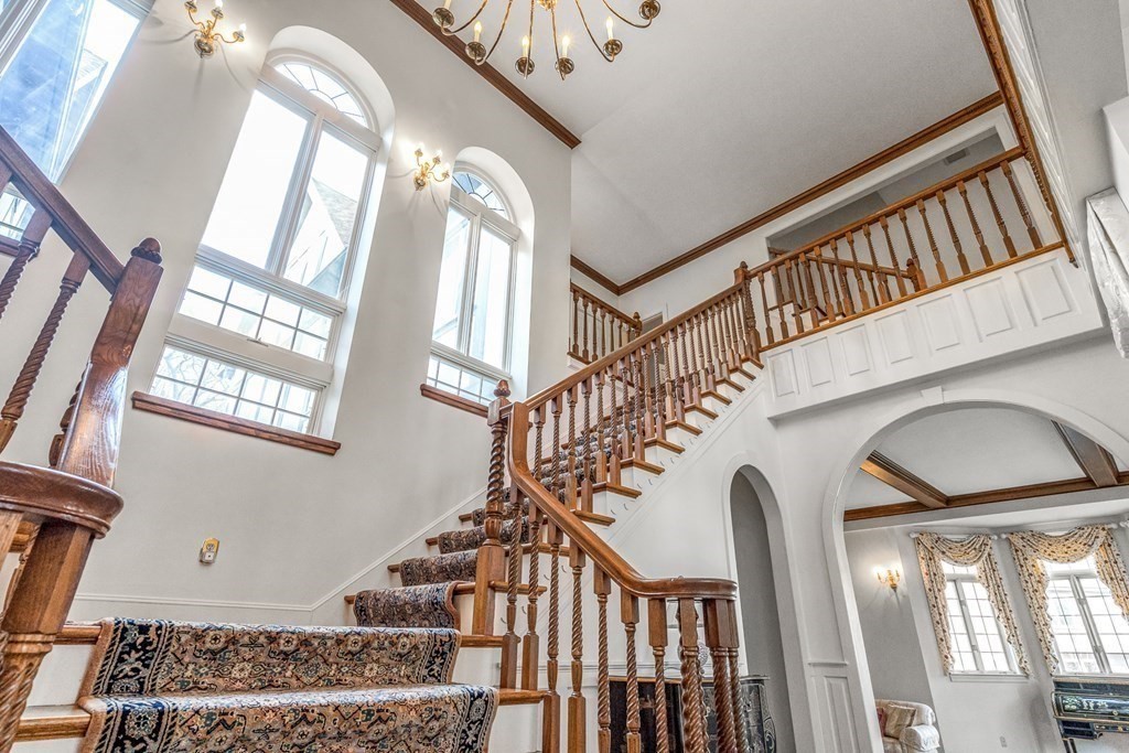 3 Myopia Road Winchester, MA 01890 - Photo 20 of 39 a view of staircase with lots of frames on wall and a chandelier