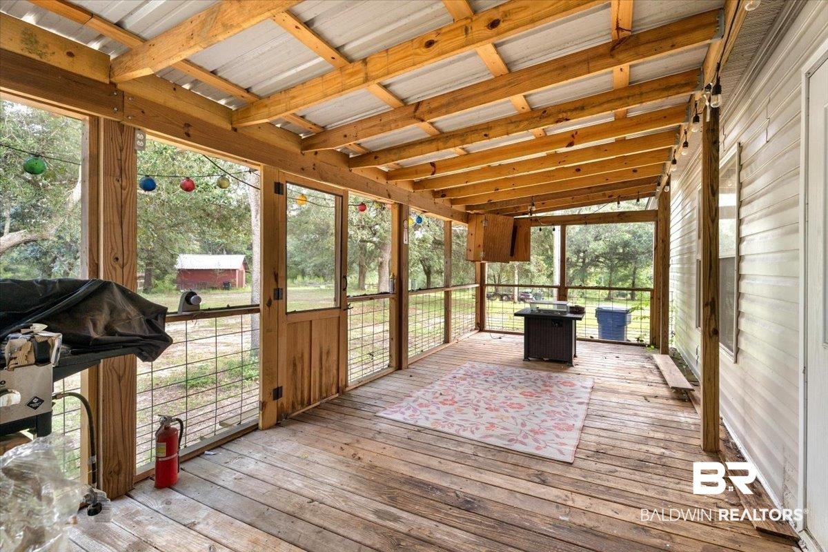 21011 River Road Robertsdale, AL 36567 - Photo 18 of 29 Screened porch featuring wood-finish flooring, exposed wood beams, and a metal roof