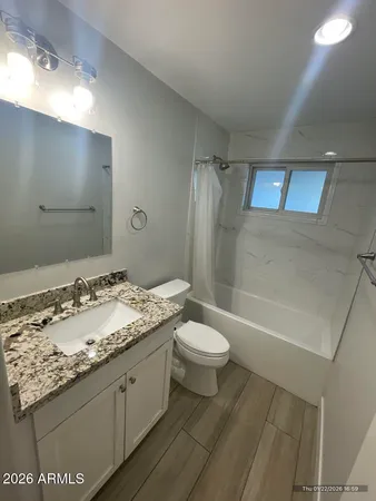 a bathroom with a granite countertop sink toilet and shower