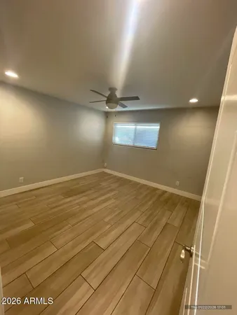 en empty room with wooden floor and fan