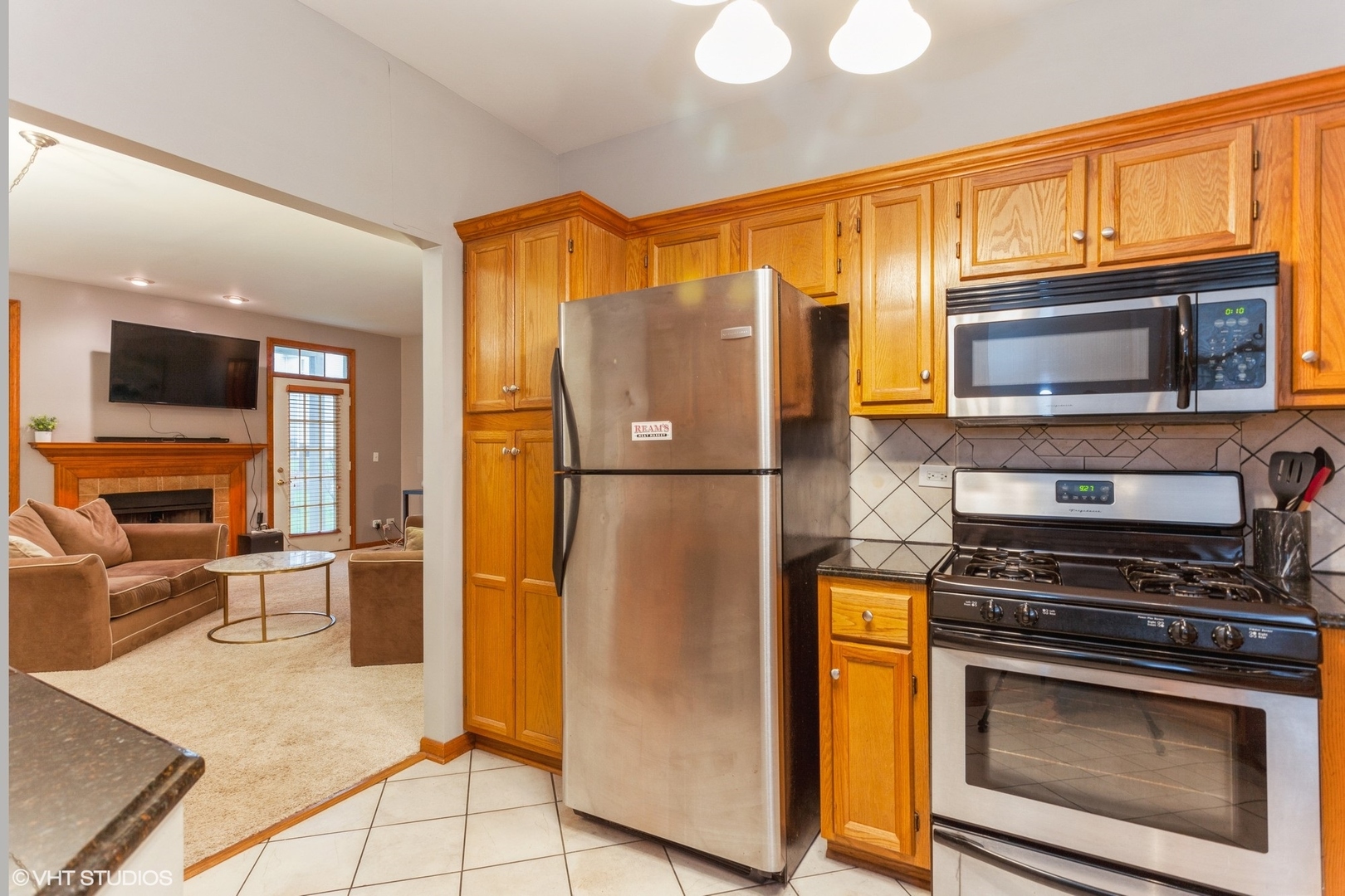 910 Prospect Court, Unit 910 Naperville, IL 60540 - Photo 11 of 17 a kitchen with granite countertop a refrigerator and a stove top oven