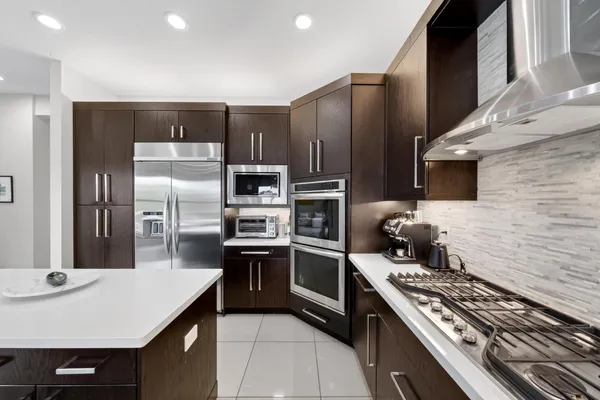 a kitchen with a sink a counter top space and living room view