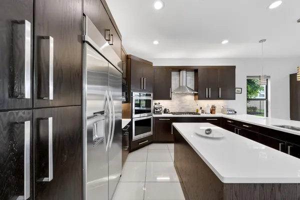 a kitchen with a sink a counter top cabinets appliances and a window