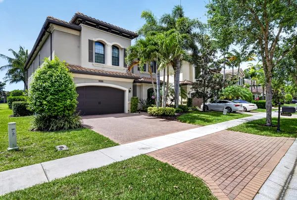 a front view of a house with a yard and potted plants