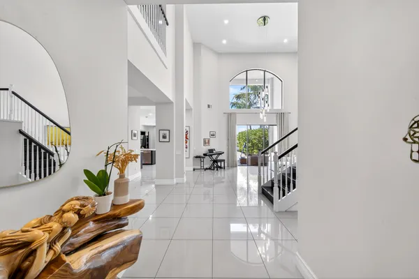 a living room with couches potted plants with wooden floor