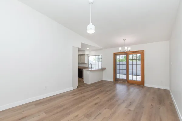 a view of a kitchen with a sink and dishwasher a refrigerator with wooden floor