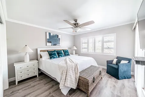 a bedroom with a large bed and a chandelier