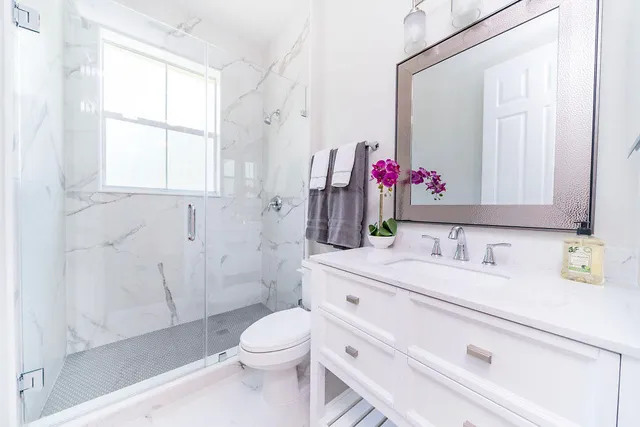 a bathroom with a sink vanity mirror and toilet
