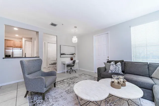 a living room with furniture and a dining table with wooden floor