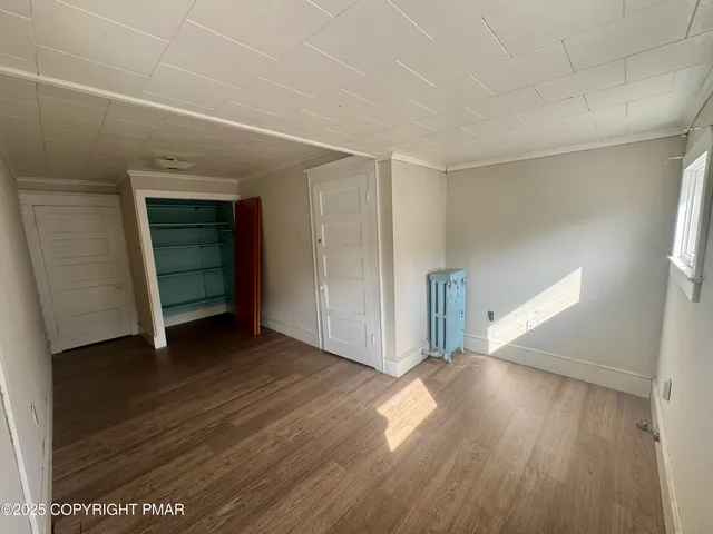 an empty room with wooden floor and closet