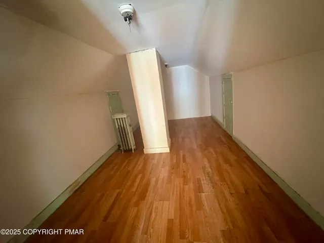 a view of a room with wooden floor and white walls