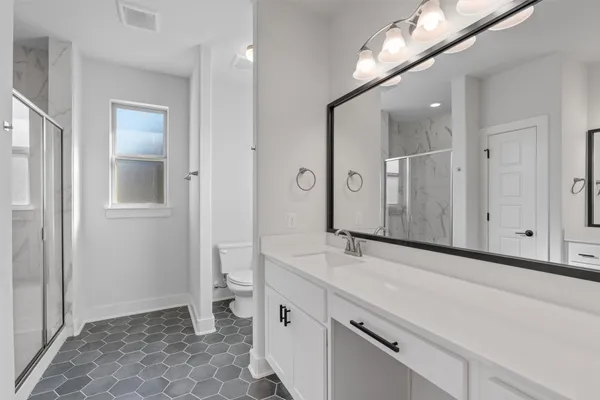 a bathroom with a sink a toilet and a large mirror