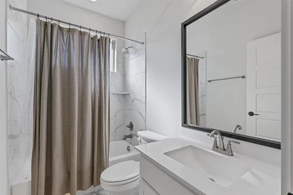 a bathroom with a sink a toilet a mirror and shower