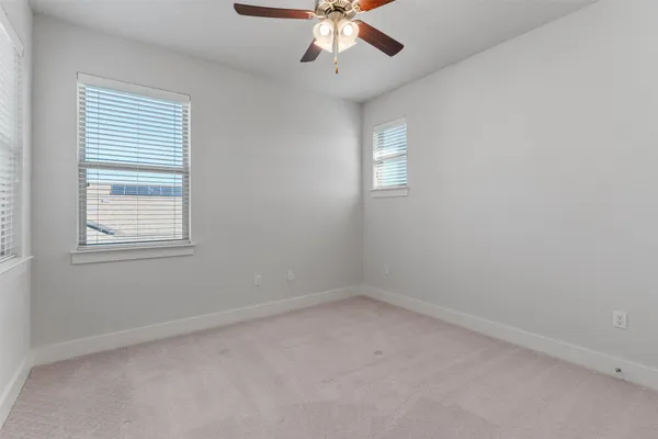 an empty room with a window and a ceiling fan