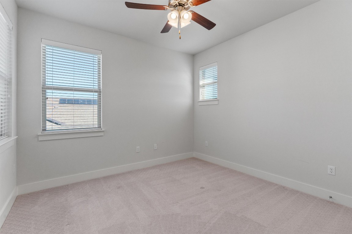 8707 Alderman Dr. Austin, TX 78747 - Photo 26 of 33 an empty room with a window and a ceiling fan