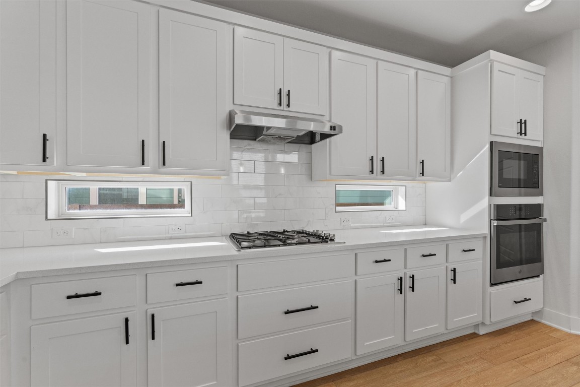 8707 Alderman Dr. Austin, TX 78747 - Photo 7 of 33 a kitchen with stainless steel appliances granite countertop white cabinets and a stove a oven with white countertops