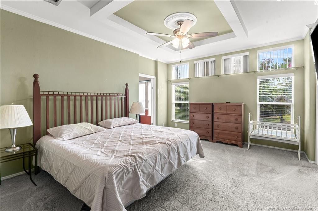 4237 4th Court Lantana, FL 33462 - Photo 22 of 40 a spacious bedroom with a bed a chandelier and a chair