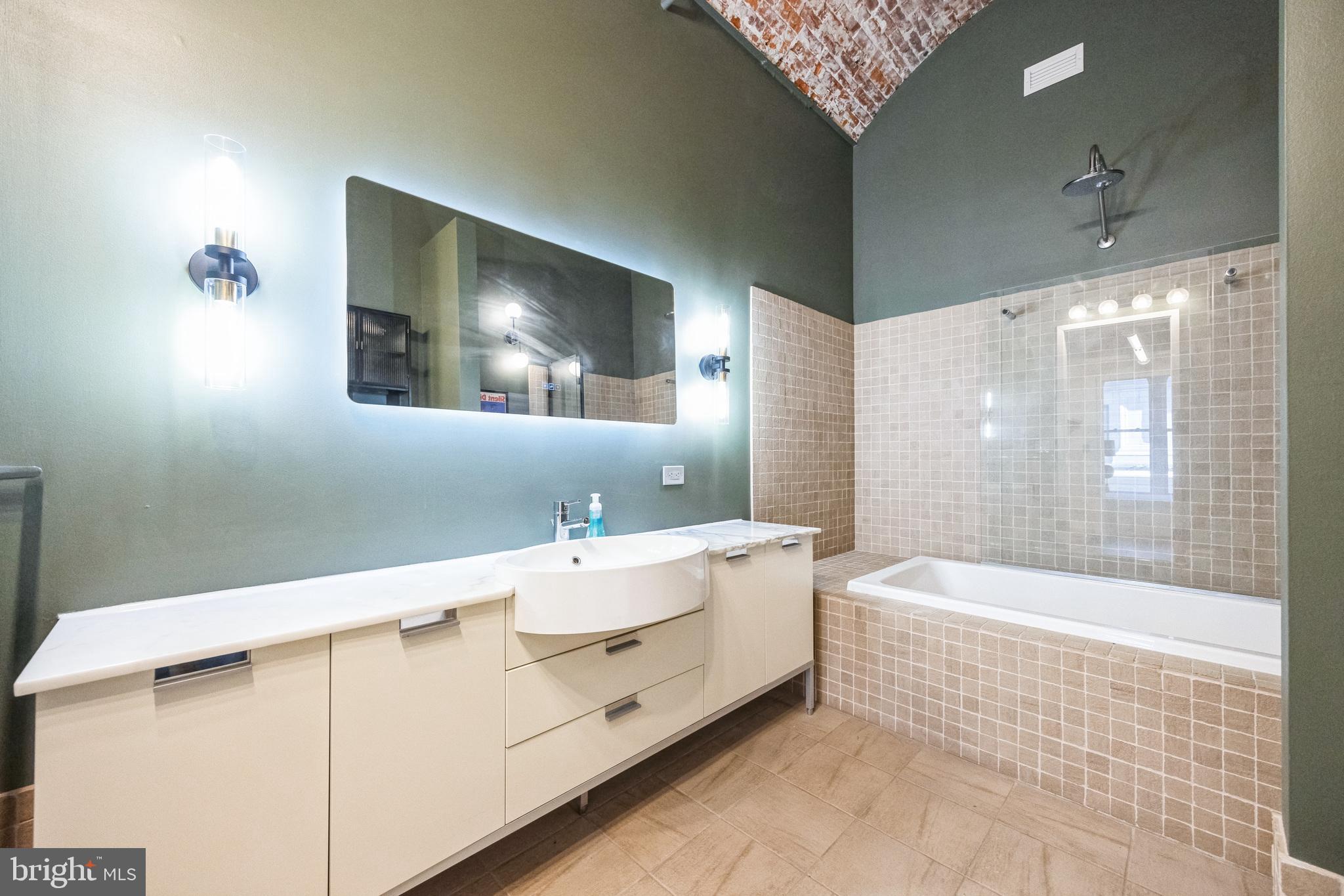105 South 12th Street, Unit 402 Philadelphia, PA 19107 - Photo 17 of 21 a bathroom with a sink a large mirror and a bathtub