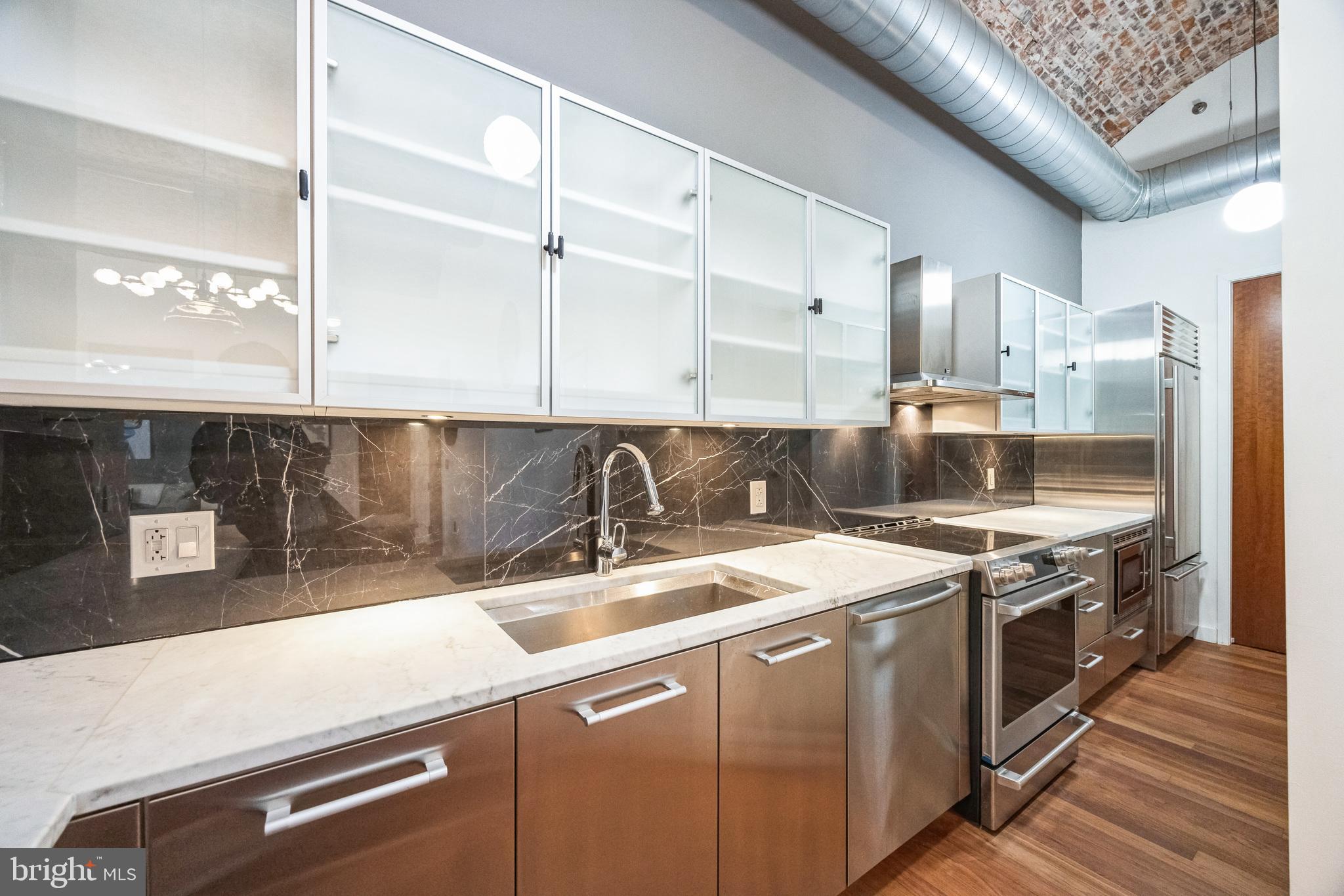105 South 12th Street, Unit 402 Philadelphia, PA 19107 - Photo 9 of 21 a kitchen with stainless steel appliances granite countertop a sink a stove and a wooden floors