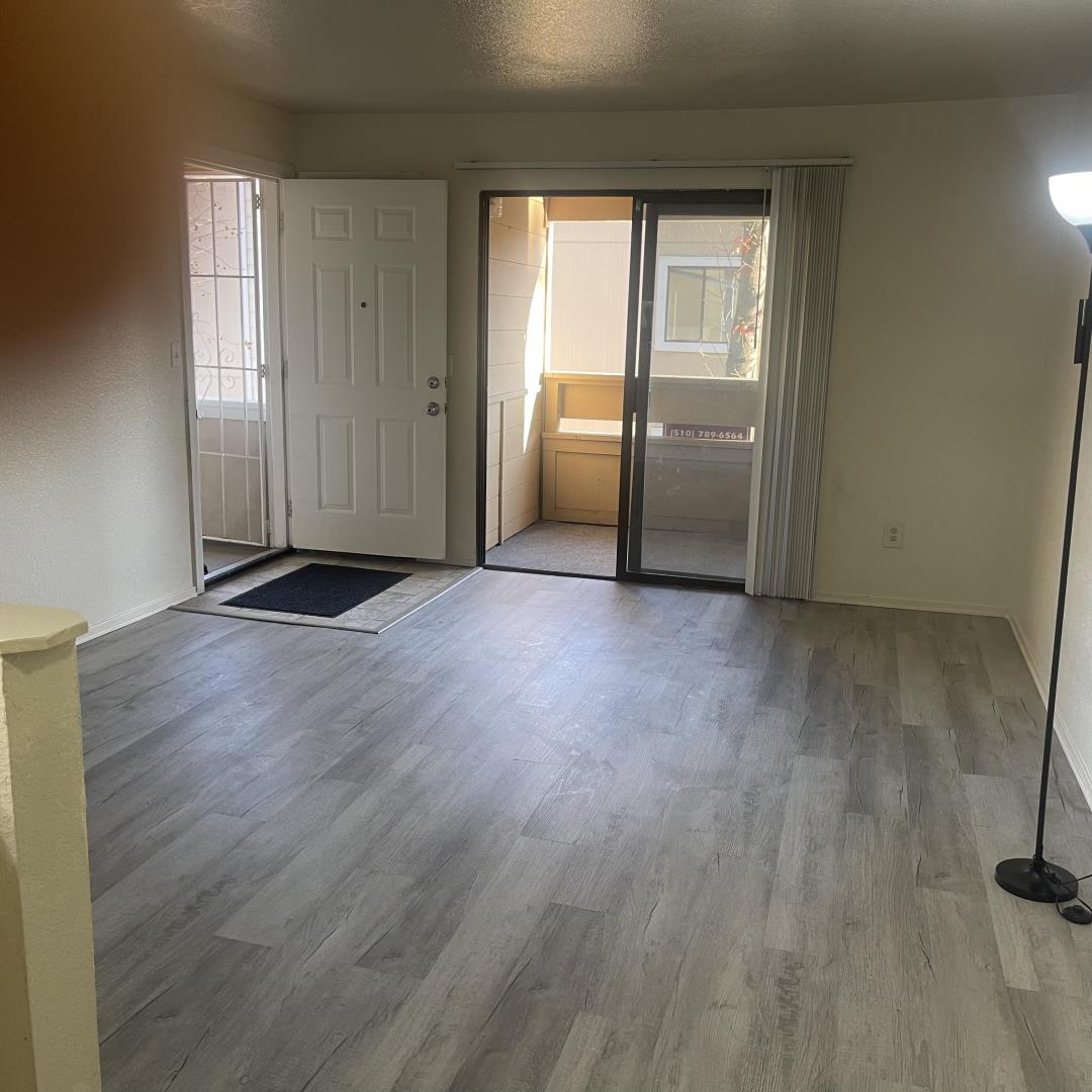 1645 Pyrenees Avenue, Unit 63 Stockton, CA 95210 - Photo 5 of 17 an empty room with wooden floor and windows