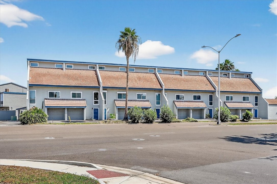 3402 Ocean Drive Corpus Christi, TX 78411 - Photo 1 of 39 a front view of a building with a garden