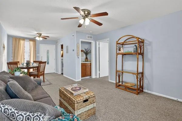 a living room with furniture a ceiling fan and a rug