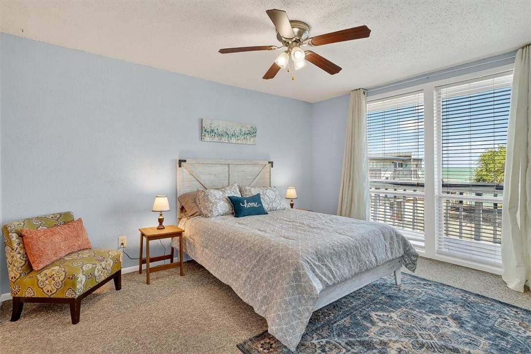 3402 Ocean Drive Corpus Christi, TX 78411 - Photo 18 of 39 a bedroom with a bed and a chandelier