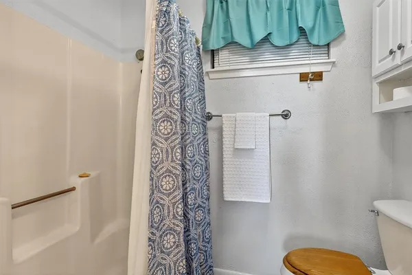 a bathroom with a toilet and a shower curtain
