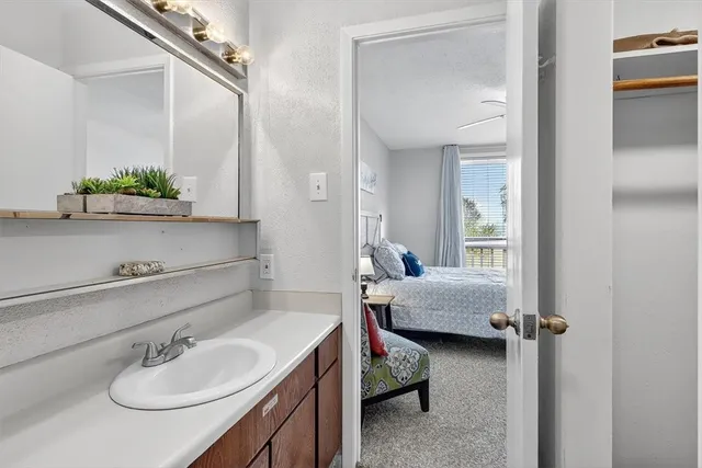 a en suite bathroom with a granite countertop sink and a mirror